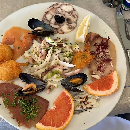Antipasto di crudi: carpaccio di polpo, salmone, tonno, calamari e frutti di mare